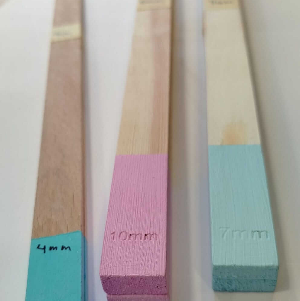 Guias de madeiras em diferentes alturas com marcações para espessuras de 4mm, 7mm e 10mm.