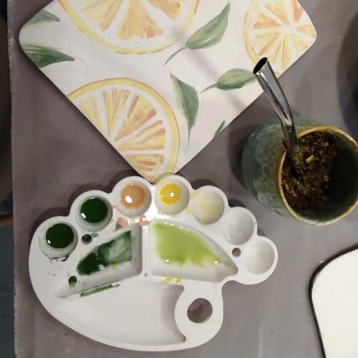 Pintura em Azulejo com paleta de cores e um fundo decorado com limões.